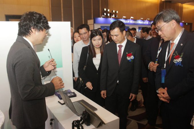 Thứ trưởng Bùi Thế Duy (giữa) cùng Thứ trưởng Park Yun Gyu (phải) tham quan gian hàng triển lãm công nghệ, thiết bị AI trong y tế. Ảnh: Đức Bình
